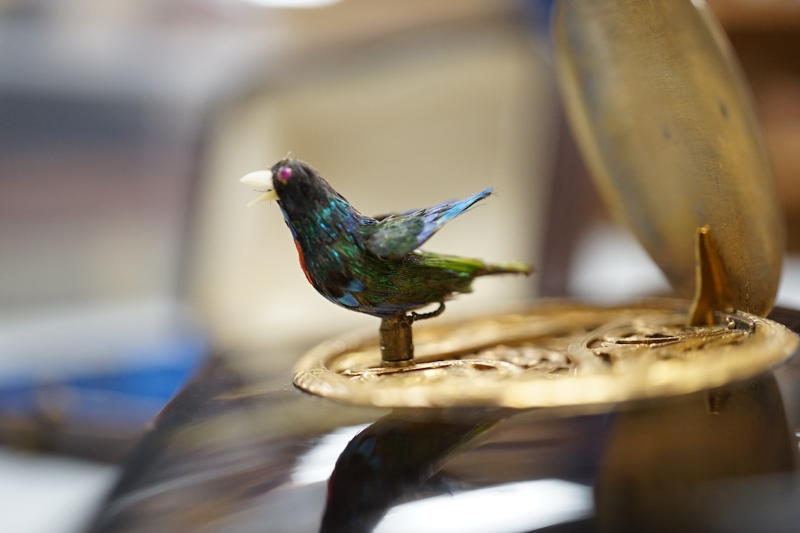 A Victorian white and yellow mounted singing automaton bird music box, damaged, with case and key